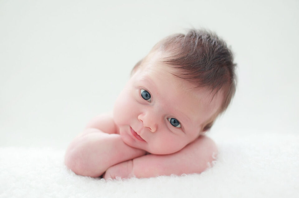 Older newborn baby with bright eyes resting on a white blanket at Sweetlife Photography North Lakes