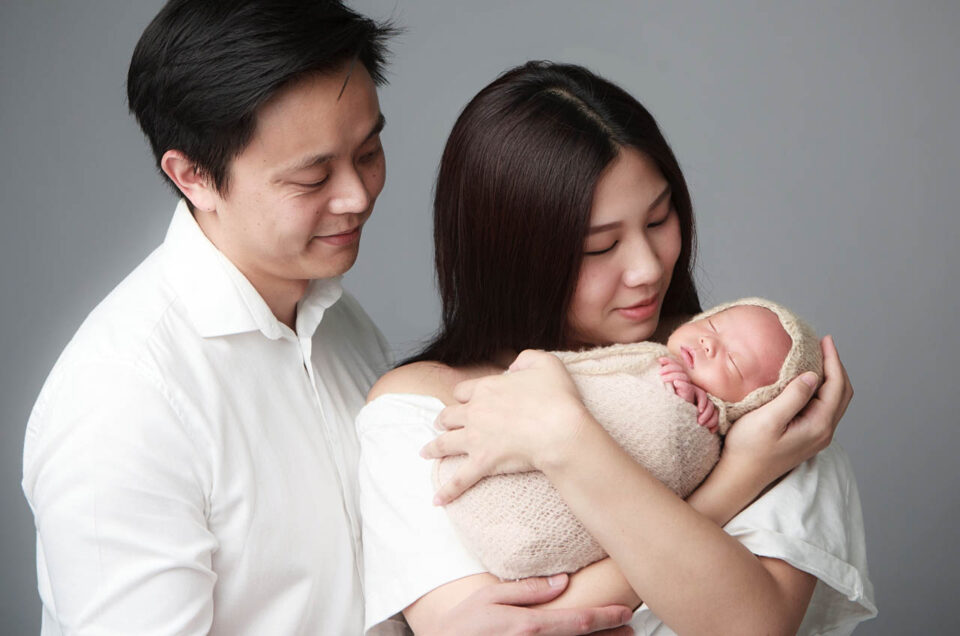 Parents holding their newborn baby in a family portrait at Sweetlife Studio North Lakes