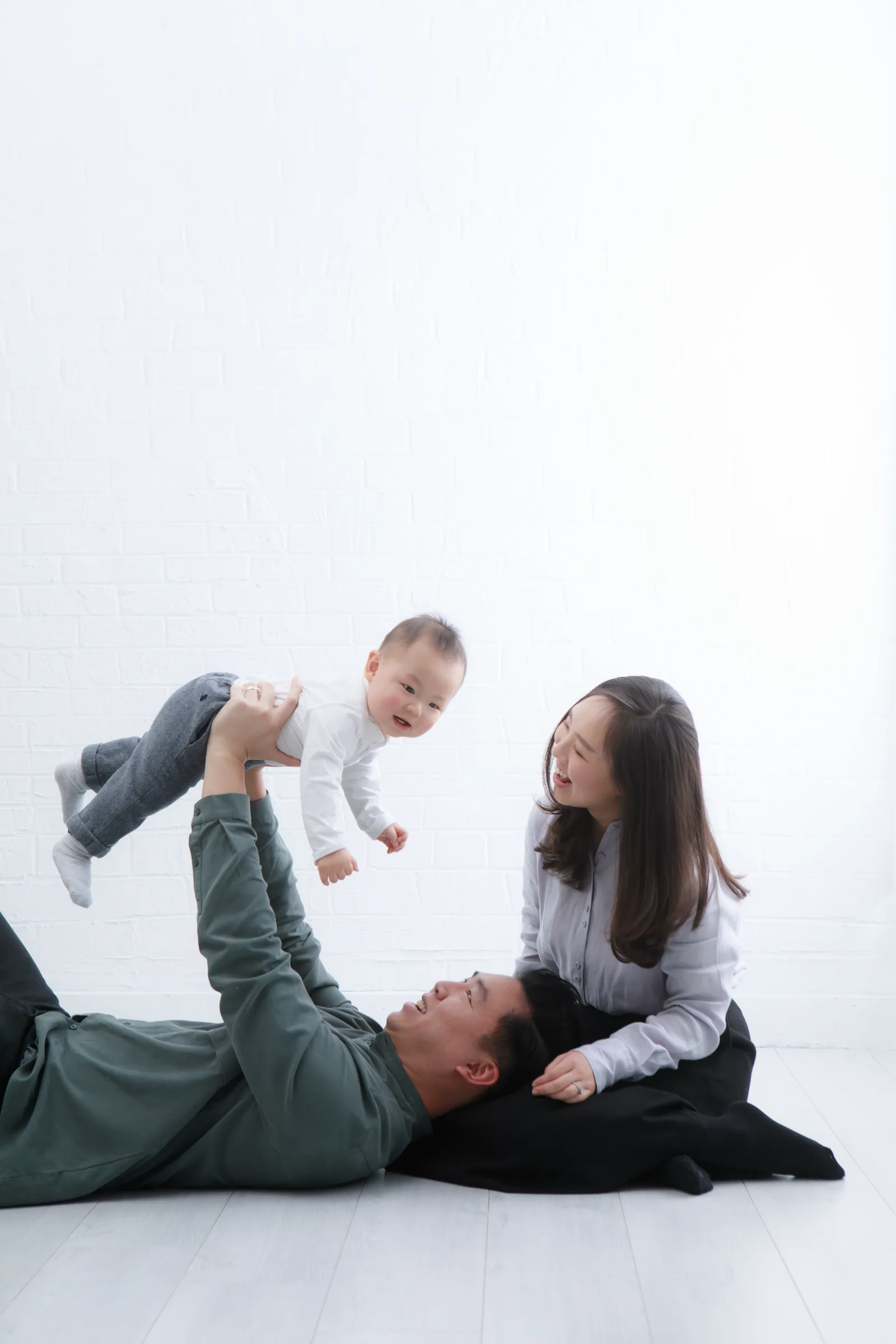 부모님과 아기가 함께 웃는 자연스러운 가족사진